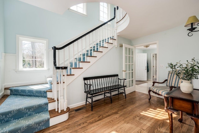 stairway featuring baseboards, visible vents, and wood finished floors