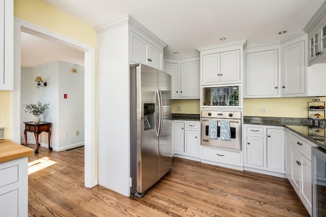 kitchen with white cabinets, light wood finished floors, beverage cooler, glass insert cabinets, and stainless steel appliances