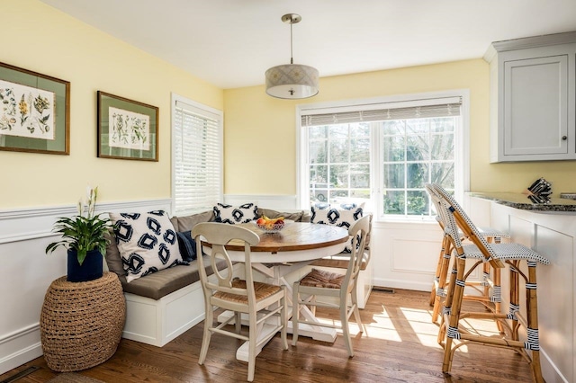 dining space featuring a wainscoted wall, plenty of natural light, light wood-type flooring, and breakfast area