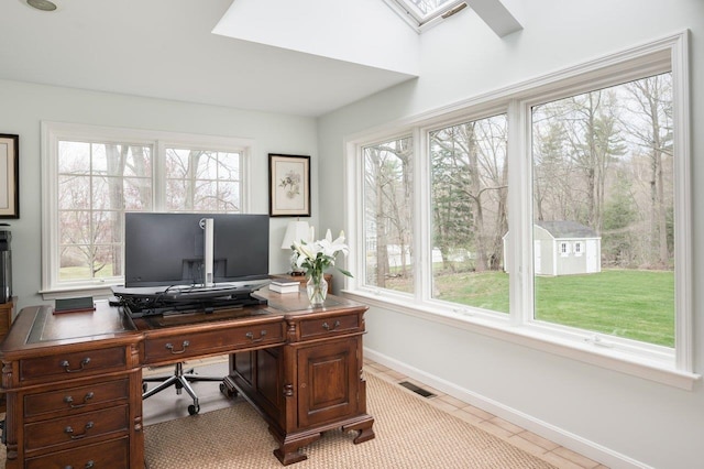 tiled office space with visible vents, baseboards, and a skylight