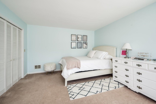 carpeted bedroom with visible vents, baseboards, and a closet