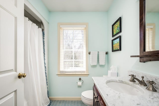 full bathroom with a healthy amount of sunlight, vanity, baseboards, and toilet