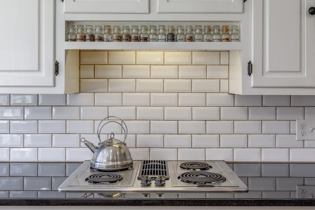 kitchen featuring dark countertops, white cabinets, backsplash, and stainless steel electric stovetop
