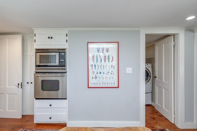 kitchen featuring washer / clothes dryer, white cabinetry, appliances with stainless steel finishes, and wood finished floors