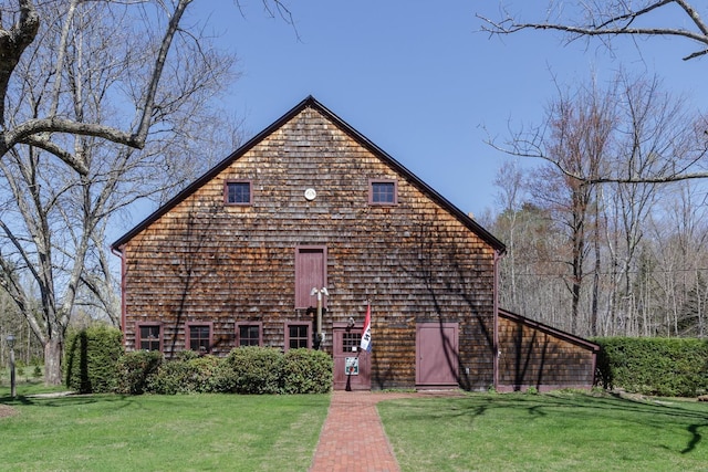 view of front of home featuring a barn and a front lawn