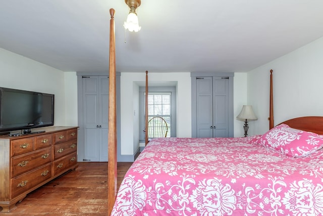 bedroom with multiple closets and dark wood-style floors
