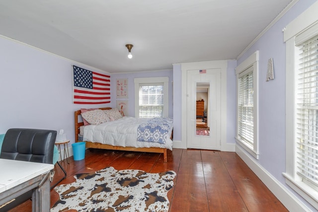 bedroom featuring crown molding, baseboards, and hardwood / wood-style flooring