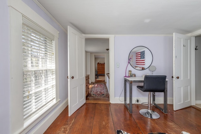 hall with crown molding, baseboards, and hardwood / wood-style flooring