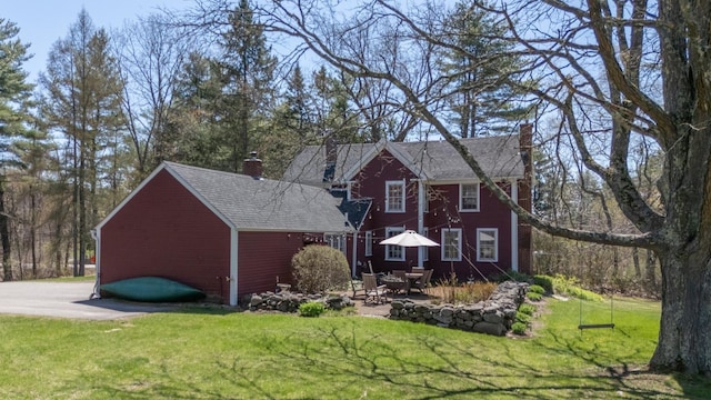 exterior space featuring a chimney, a yard, and a patio area