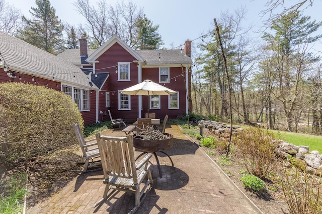 back of house with a patio area and a chimney