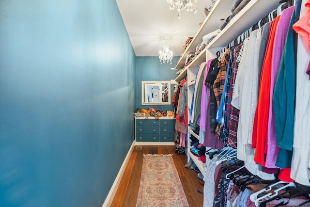 walk in closet featuring an inviting chandelier and wood finished floors