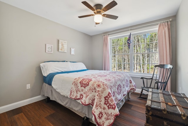 bedroom with a ceiling fan, baseboards, and dark wood-type flooring