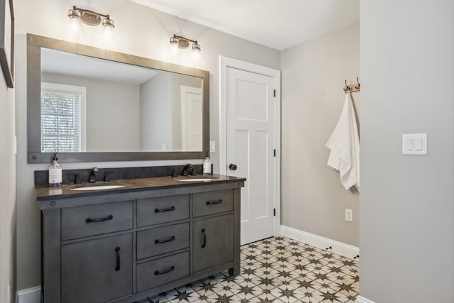 bathroom with double vanity, a sink, baseboards, and tile patterned floors