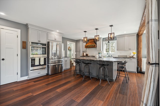 kitchen with custom range hood, a sink, gray cabinets, and appliances with stainless steel finishes
