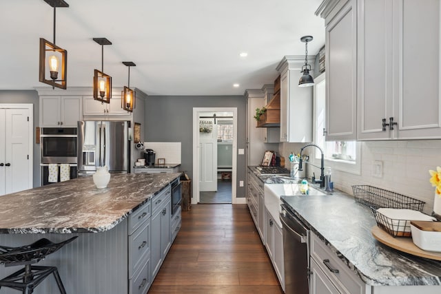 kitchen with plenty of natural light, recessed lighting, appliances with stainless steel finishes, and dark wood-type flooring