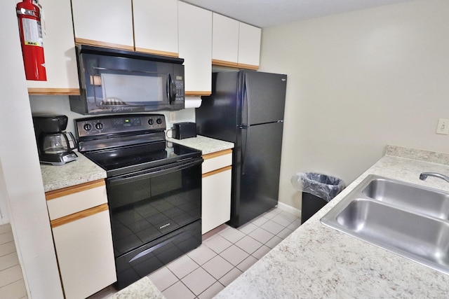 kitchen featuring white cabinetry, a sink, light countertops, black appliances, and light tile patterned flooring