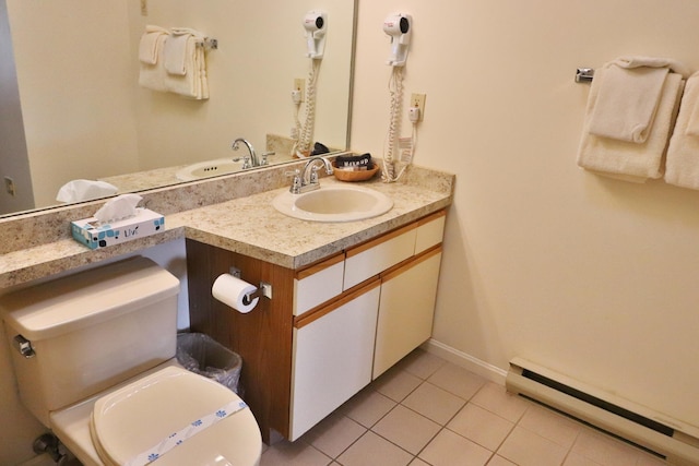 half bathroom with tile patterned floors, a baseboard radiator, vanity, and toilet