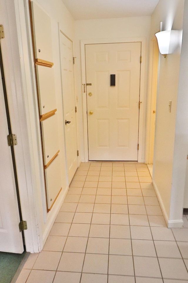 doorway to outside with baseboards and light tile patterned floors