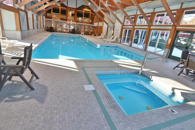 community pool featuring an indoor in ground hot tub and a patio area