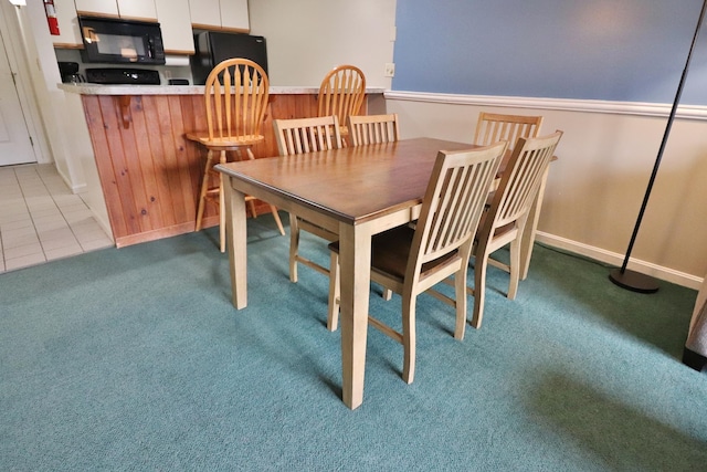dining room with carpet floors and tile patterned flooring