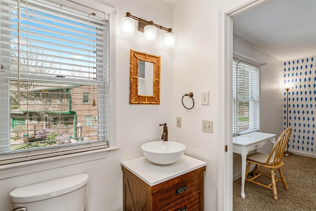 bathroom featuring vanity, plenty of natural light, and toilet