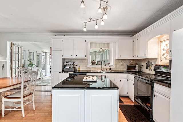 kitchen featuring a sink, dark countertops, electric range, and light wood-style flooring