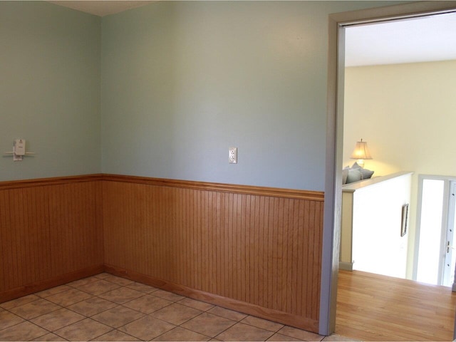 unfurnished room featuring a wainscoted wall