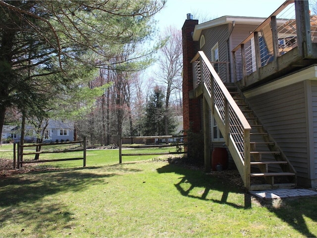 view of yard featuring fence and stairs