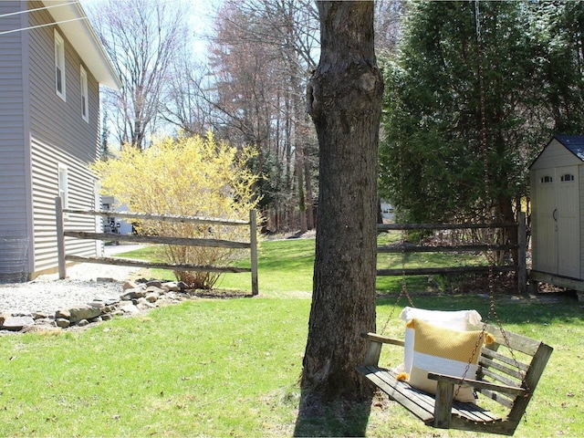 view of yard featuring a storage shed, fence, and an outdoor structure