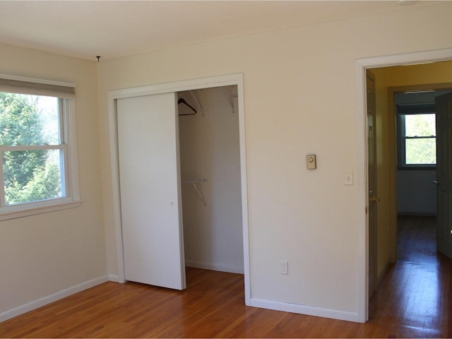 unfurnished bedroom with baseboards, a closet, and wood finished floors