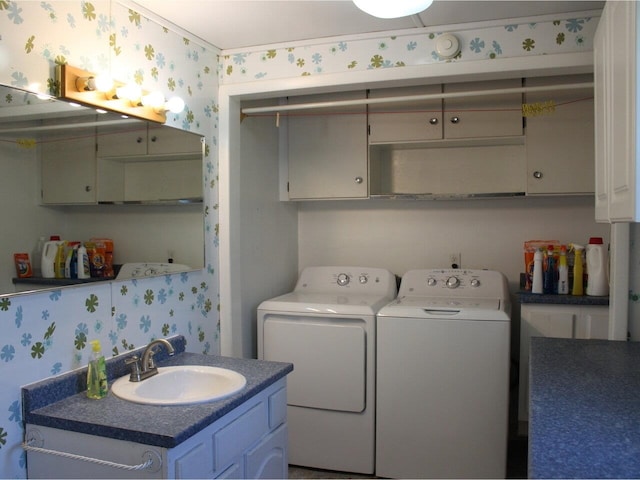 washroom with a sink, washing machine and dryer, and wallpapered walls