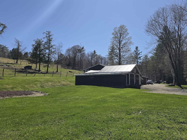 view of yard with fence, an outbuilding, and a pole building