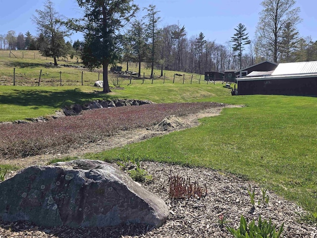 view of yard with fence and a rural view