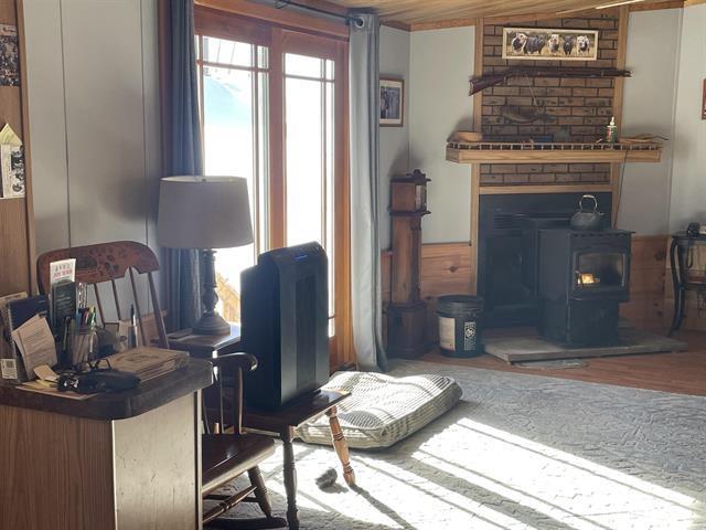 living room with a wood stove and wood finished floors
