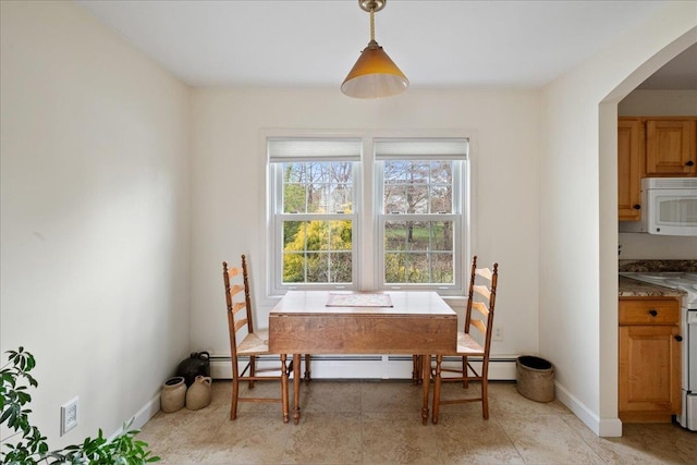 dining space with arched walkways and baseboards