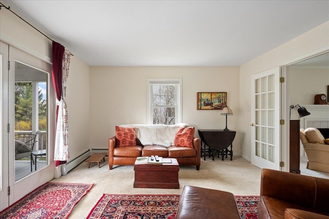 living room featuring plenty of natural light, a baseboard heating unit, and light carpet