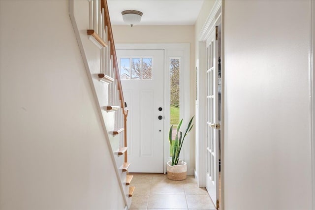 doorway with stairs and light tile patterned flooring