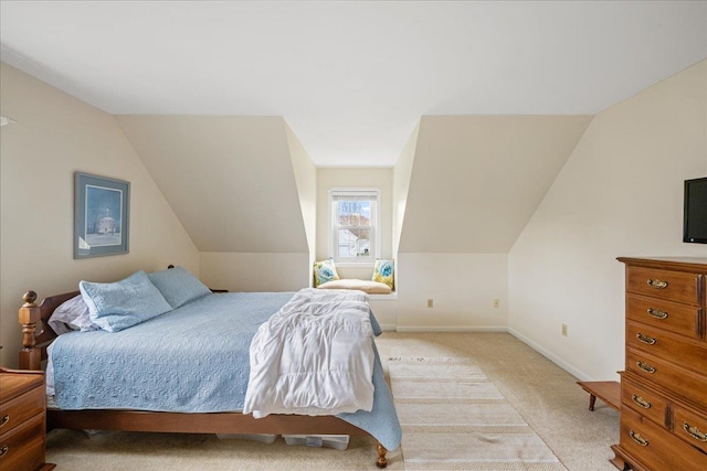 bedroom with light colored carpet, baseboards, and vaulted ceiling