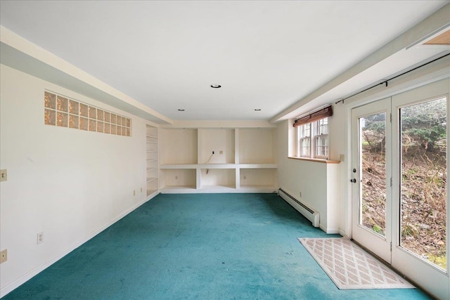 carpeted empty room with baseboards, a baseboard radiator, and built in shelves