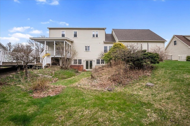 rear view of house featuring a lawn, stairs, and a deck