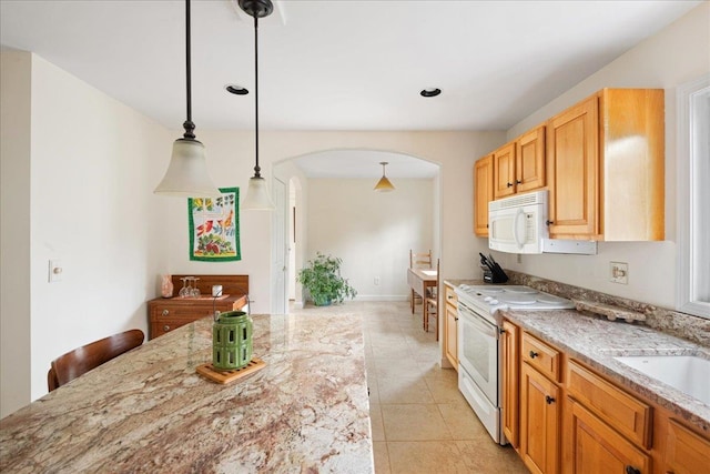 kitchen with white appliances, light stone countertops, arched walkways, light tile patterned floors, and decorative light fixtures