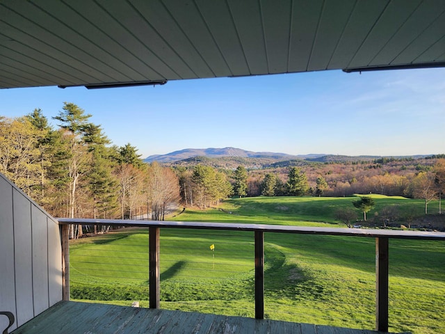 view of yard with a balcony, a mountain view, and a wooded view