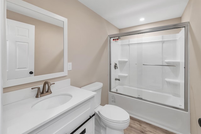 bathroom with vanity, toilet, enclosed tub / shower combo, recessed lighting, and wood finished floors