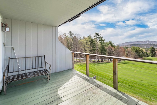 wooden terrace featuring a lawn and a mountain view