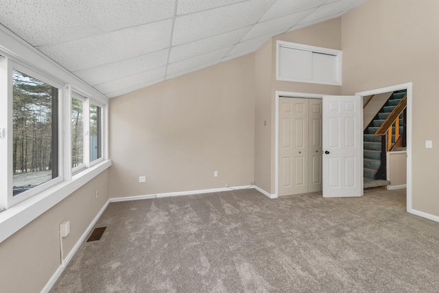 unfurnished bedroom with visible vents, carpet, baseboards, and a drop ceiling