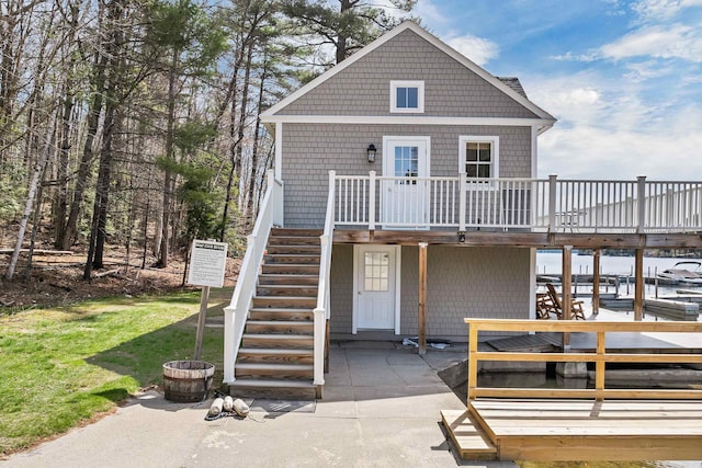 view of front of house featuring a patio area, a wooden deck, a front yard, and stairway