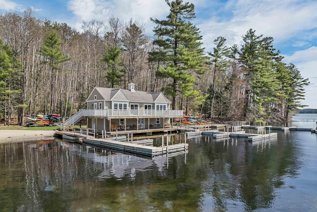 dock area featuring stairs, a water view, and a view of trees