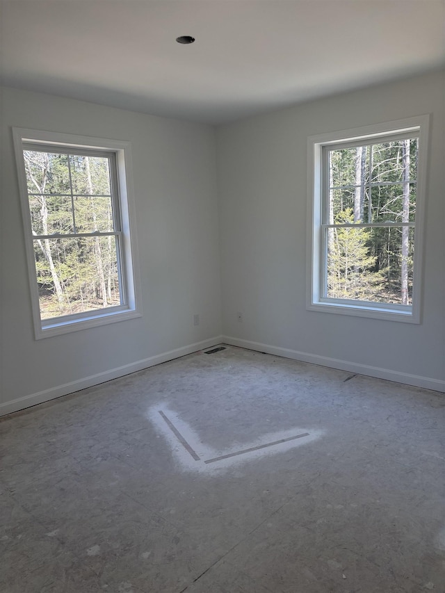 spare room with baseboards and visible vents