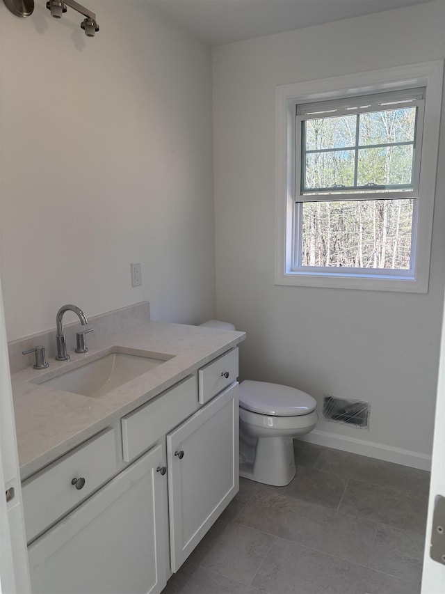 bathroom featuring vanity, baseboards, and toilet
