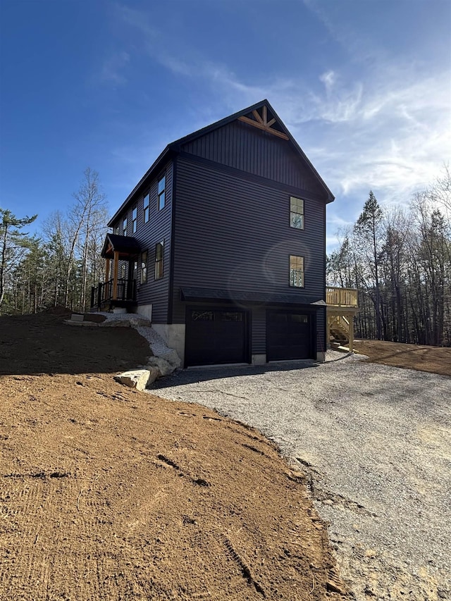 view of property exterior with gravel driveway and a garage